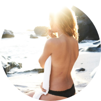 woman sat on a beach to show successful private weight loss programme